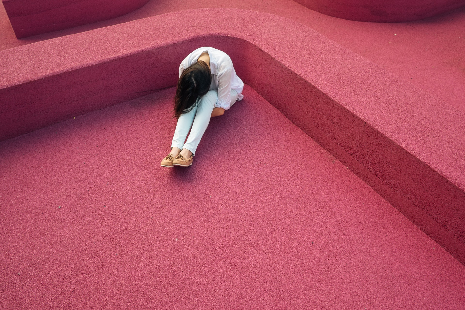 hypnotherapy for vaginismus treatment; a women sitting on the ground with her head on her knees