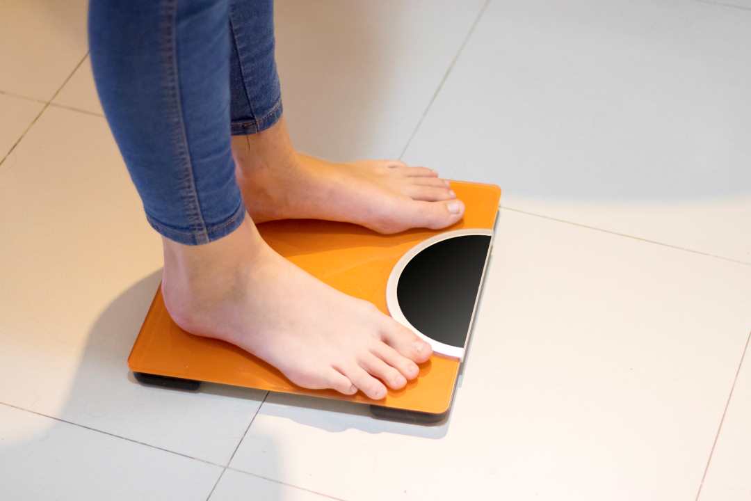 dealing with menopause, a woman measuring her weight