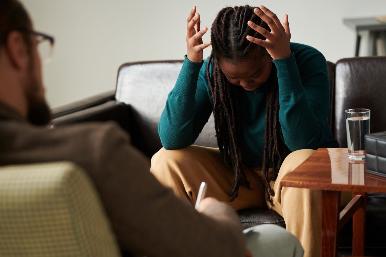 Signs of anger management issues, a women holding her head in frustration
