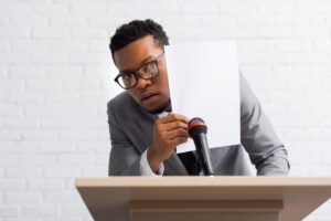 overcoming presentation anxiety, a man hiding his face behind a paper