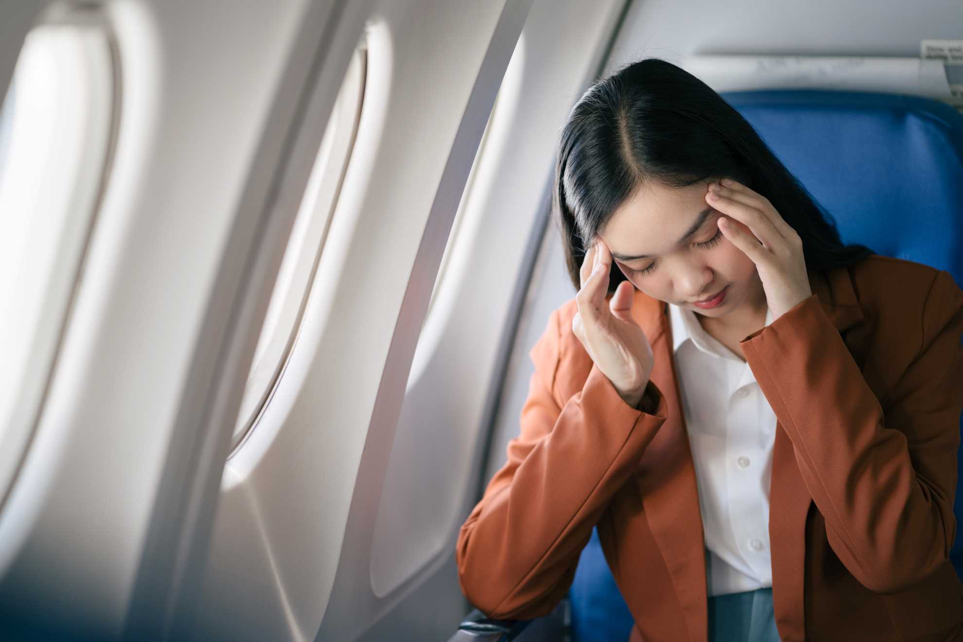 fear of flying in an aeroplane, a woman appearing stressed on a plane