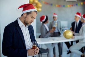 gut-focused hypnotherapy, man feeling anxious with IBS in office party